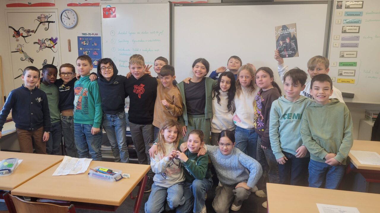 De leerlingen van klas 4A tonen (rechts achteraan) het vorige nummer van onze Aansteker